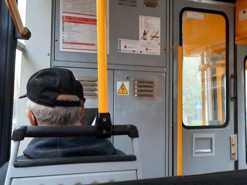 Starszy mężczyzna w strefie buforowej tramwaju