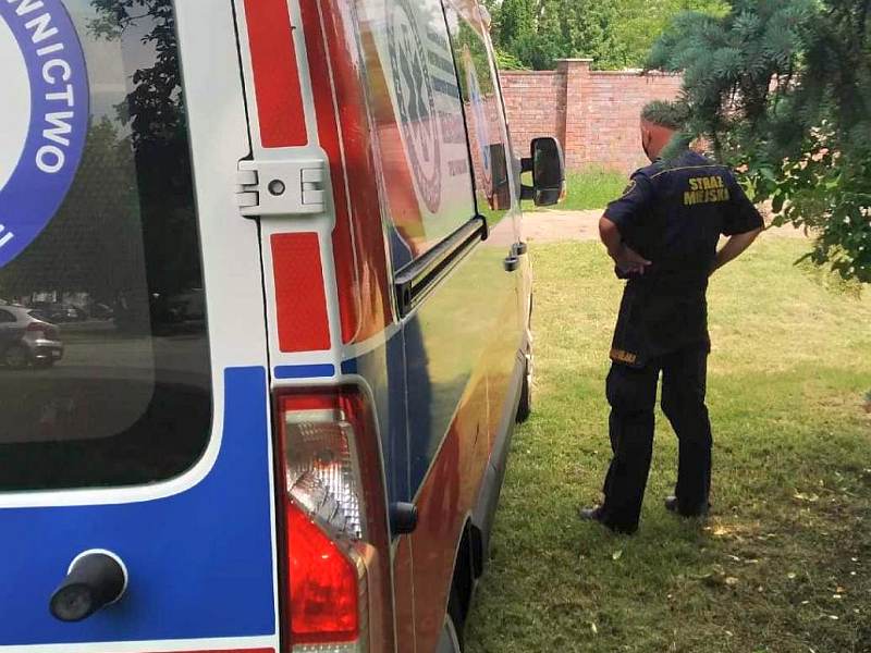 Stojący przy karetce pogotowia strażnik miejski na miejscu zdarzenia