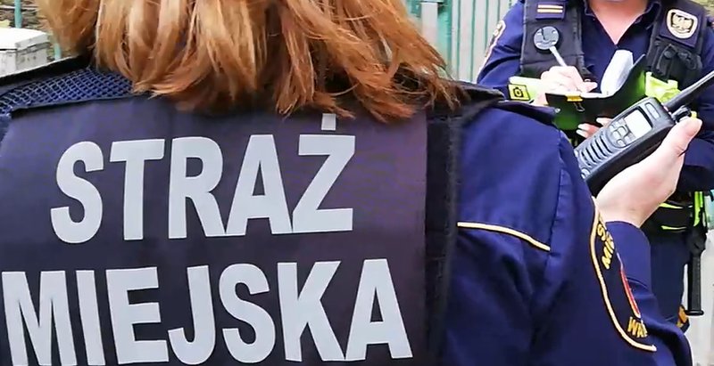 Strażniczka miejska z radiostacją w ręku