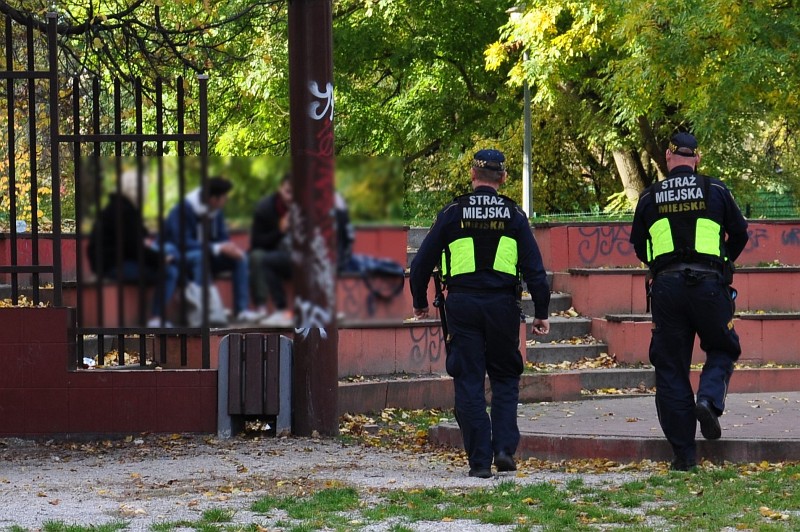 Zdjęcie ilustracyjne: patrol Straży Miejskiej podchodzący do grupki młodzieży siedzącej na ławkach.