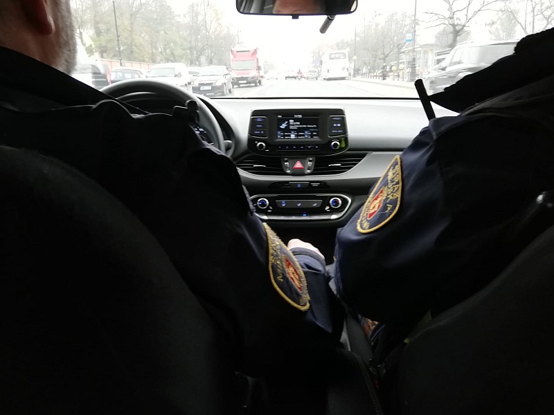 Zdjęcie ilustracyjne: dwóch strażników miejskich w&nbsp;radiowozie straży.