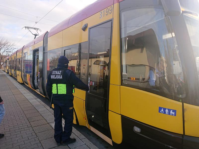 Zdjęcie ilustracyjne: strażnik  miejski przy drzwiach wejściowych do tramwaju.