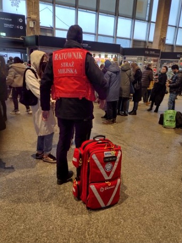 Strażnik miejski w kamizelce ratownika medycznego na Dworcu Zachodnim, wśród uchodźców z Ukrainy