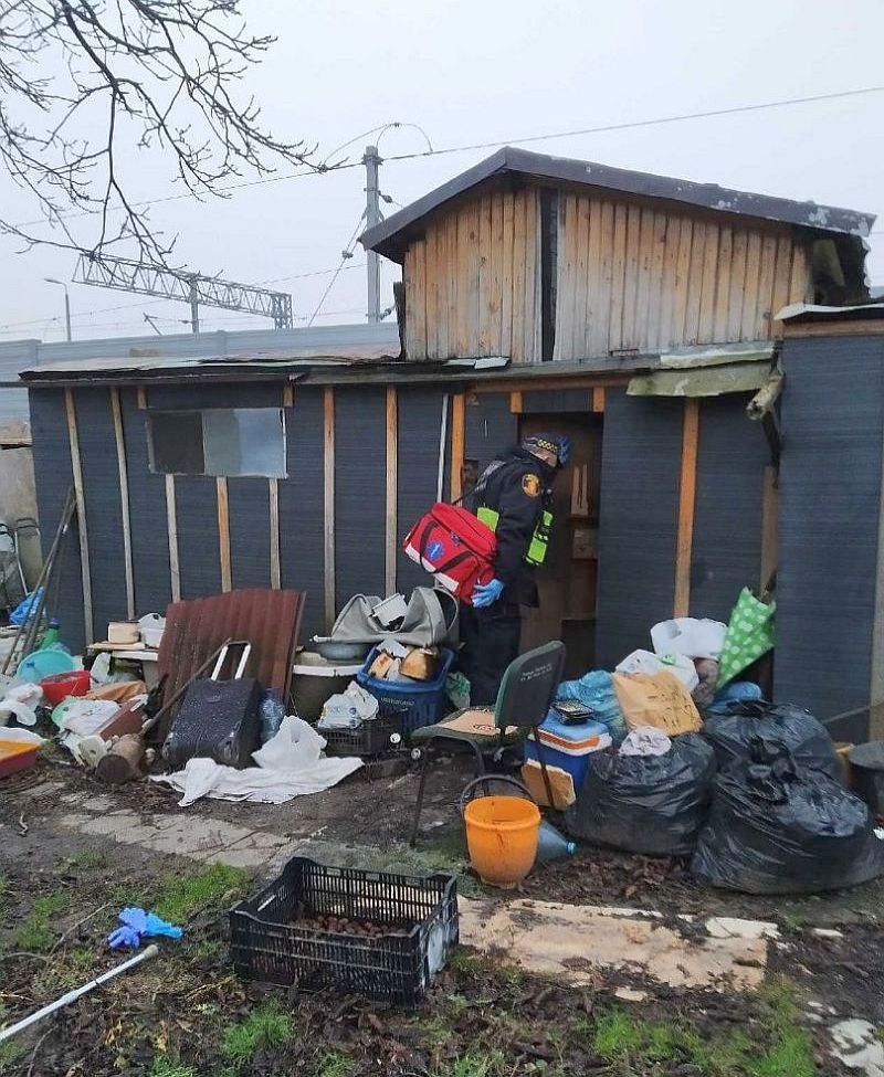 Strażnik miejski przy komórce zamieszkiwanej przez bezdomnego