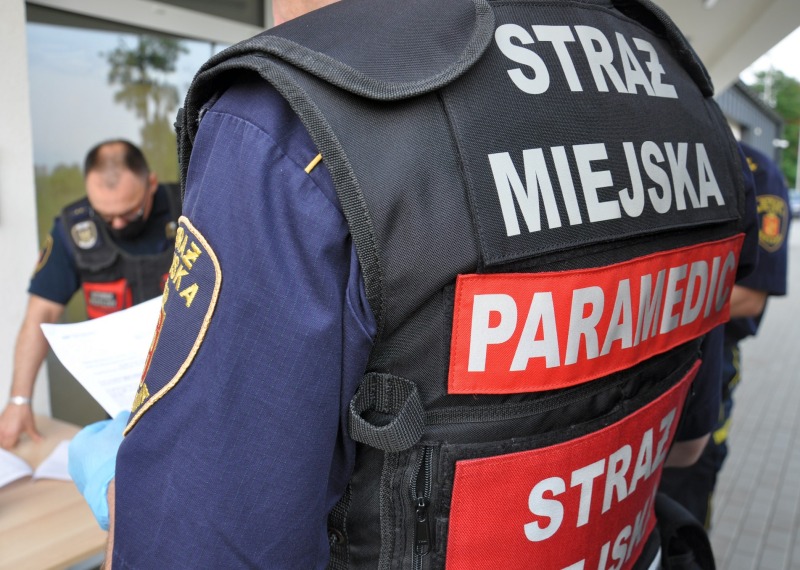 Strażnik w&nbsp;kamizelce ratownika medycznego przy stanowisku do szczepień