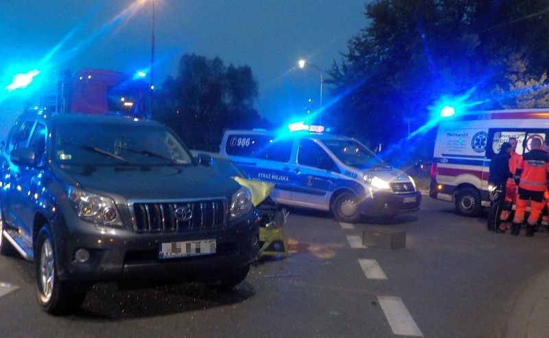 Zdjęcie z&nbsp;interwencji: na pierwszym planie biorąca udział w&nbsp;kolizji toyota, za nią stoi zabezpieczający miejsce zdarzenia radiowóz straży miejskiej. Z&nbsp;prawej strony karetka pogotowia z&nbsp;grupą ratowników.