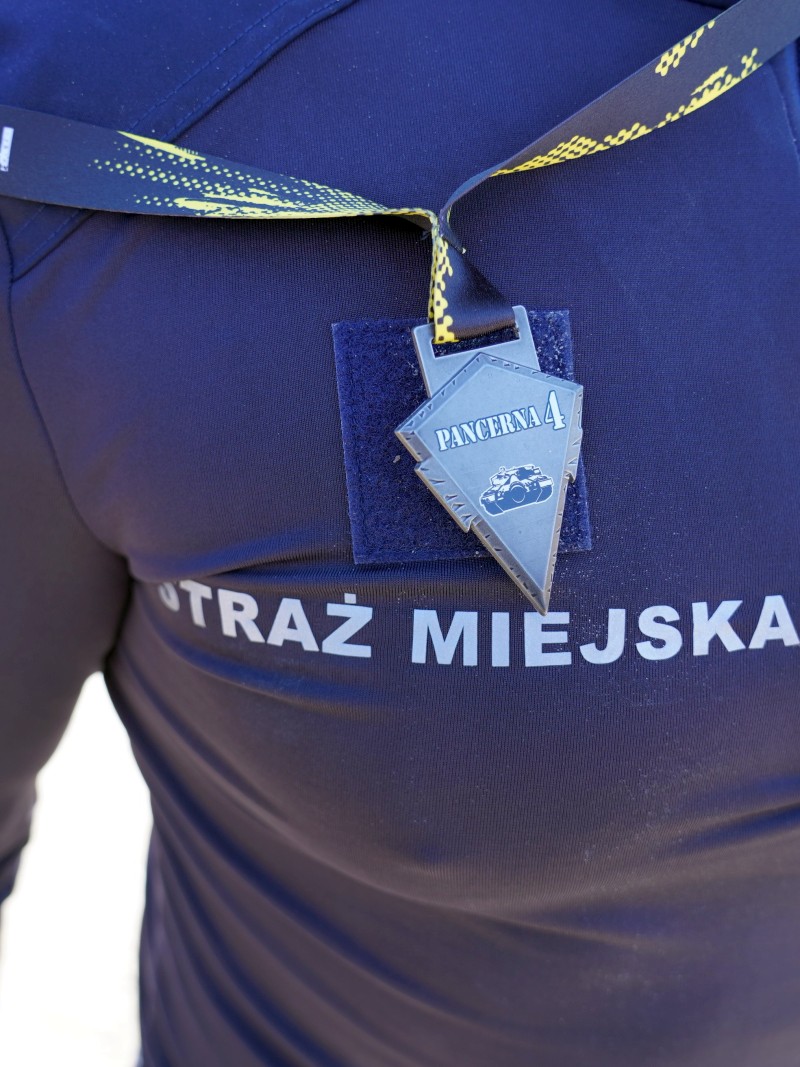 Medal ukończenia "Pancernej czwórki" na piersi strażniczki miejskiej.